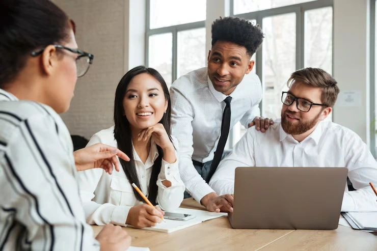 Diverse team collaborating around laptop in office