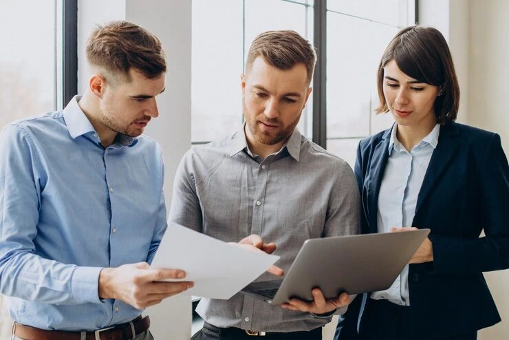 Three professionals reviewing PR documents together