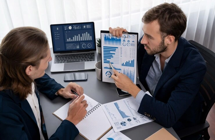 Data analytics consultant London presenting comprehensive reporting analysis to client with charts and dashboards