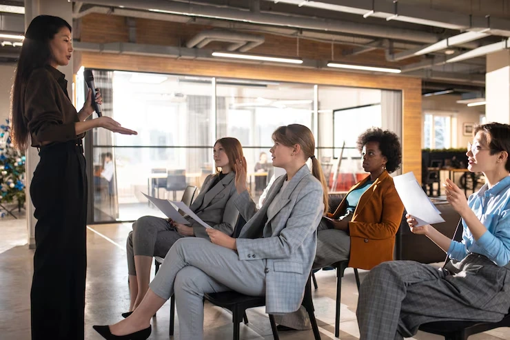 Female consultant delivering leadership development workshop to diverse group of business professionals