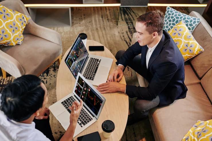 Two digital consultants collaborating on laptops showcasing technical expertise and strategic planning