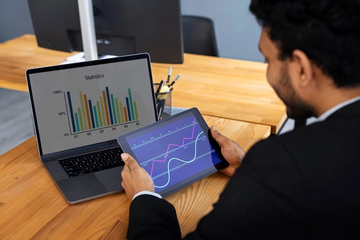 Business professional analyzing statistics and trend data on laptop and tablet for Google Analytics consulting