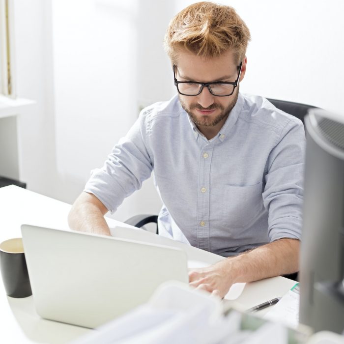 Young businessman using laptop at desk