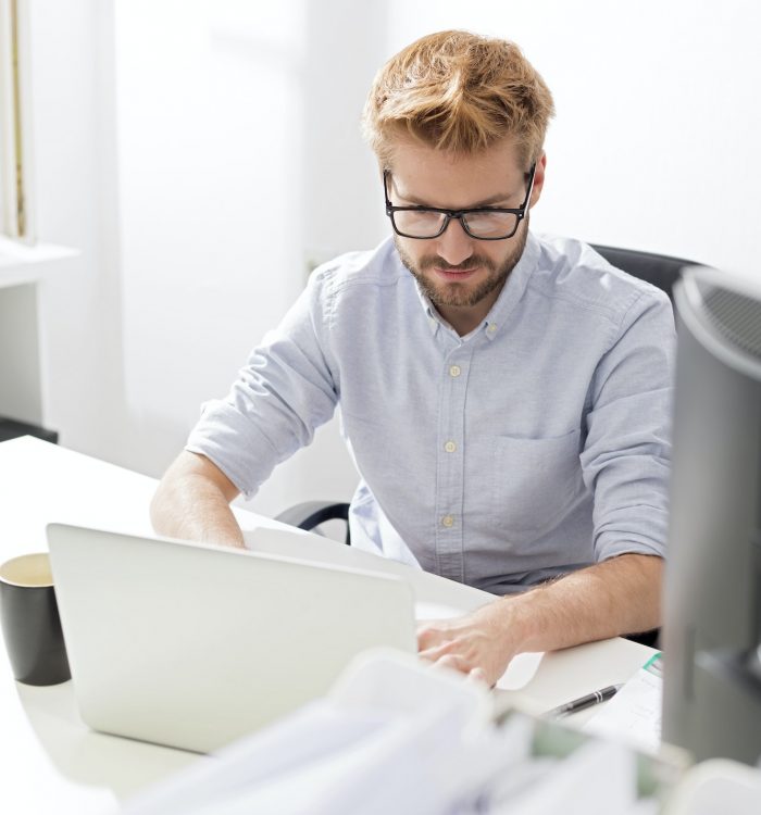 Young businessman using laptop at desk