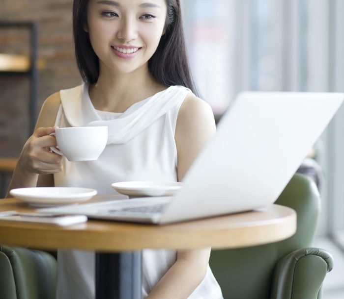 Young woman working with laptop in café